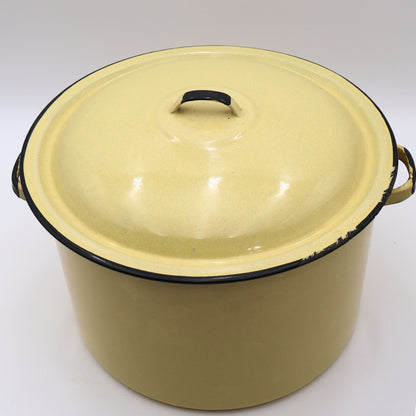 Angled front view of a vintage yellow enamelware stock pot with matching lid showcasing its classic farmhouse silhouette, black trim, and warm buttery yellow finish. A timeless piece for cottagecore décor, vintage kitchen collections, and rustic home styling.