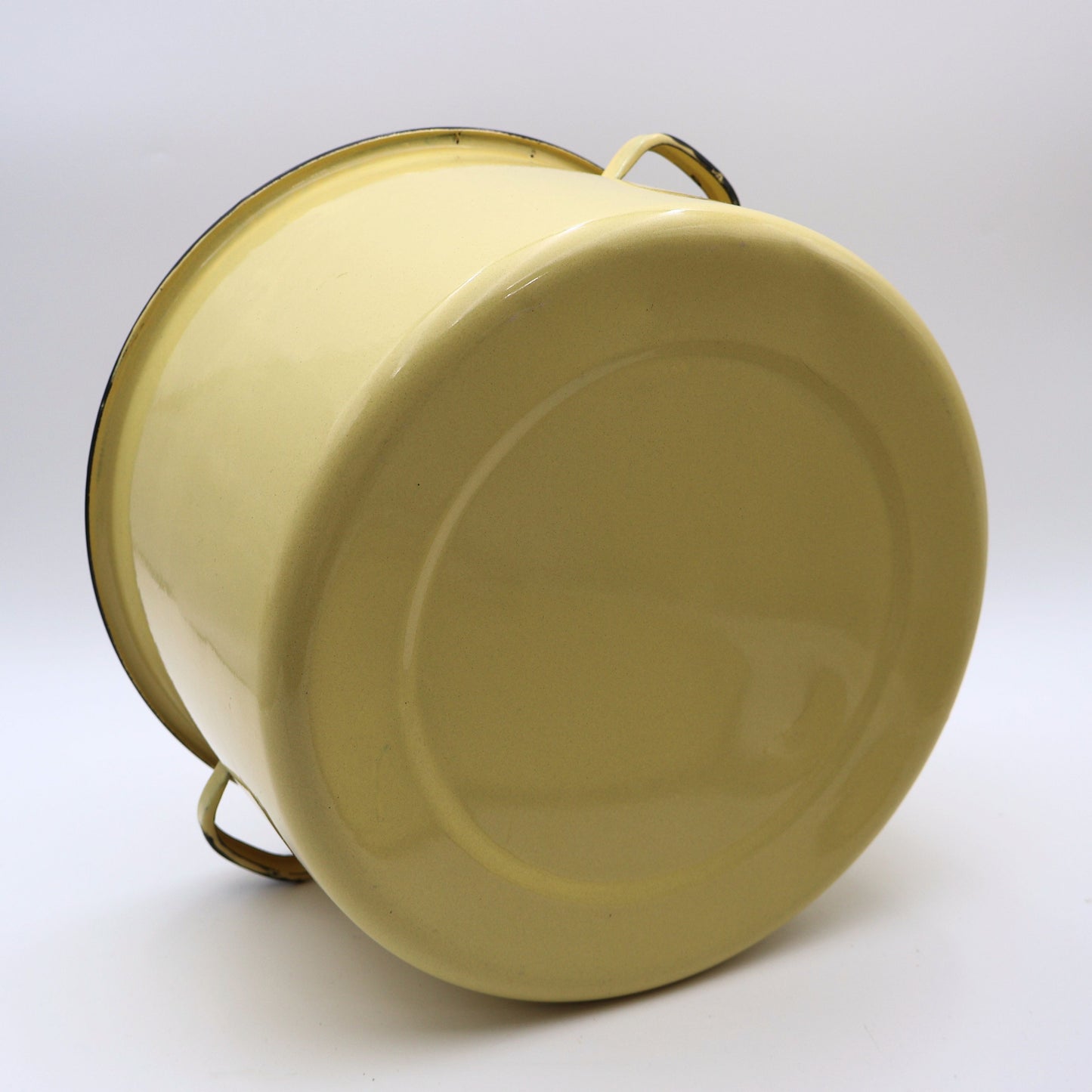 Bottom view of a vintage yellow enamelware stock pot showing the porcelain enamel finish and authentic vintage construction. A charming farmhouse kitchen collectible perfect for rustic decorating and enamelware enthusiasts.