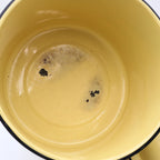 Close-up of the interior of a vintage yellow enamelware stock pot highlighting utensil marks and authentic enamel wear consistent with decades of careful use. A beautiful example of well-loved vintage farmhouse kitchenware.