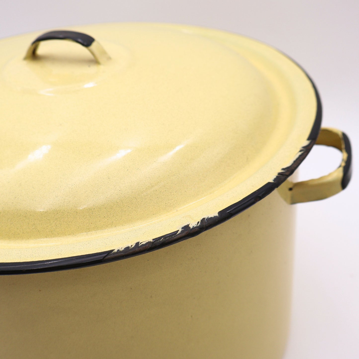 Close-up detail of the matching vintage yellow enamelware lid highlighting the glossy porcelain enamel finish, black rolled edge, and classic mid-century craftsmanship. A timeless farmhouse kitchen collectible with authentic vintage charm.