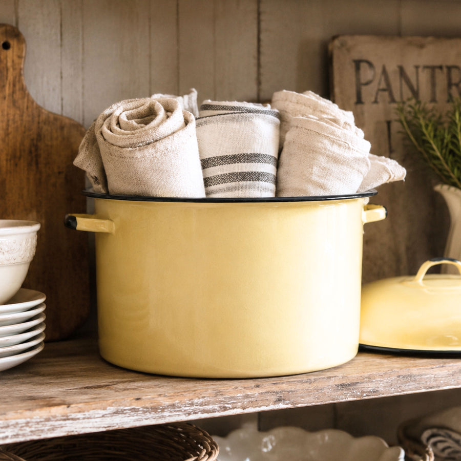 Vintage yellow enamelware stock pot styled on a rustic farmhouse pantry shelf filled with rolled linen towels. This authentic mid-century enamelware pot brings timeless farmhouse kitchen decor, cottagecore charm, and vintage storage inspiration to a collected home.