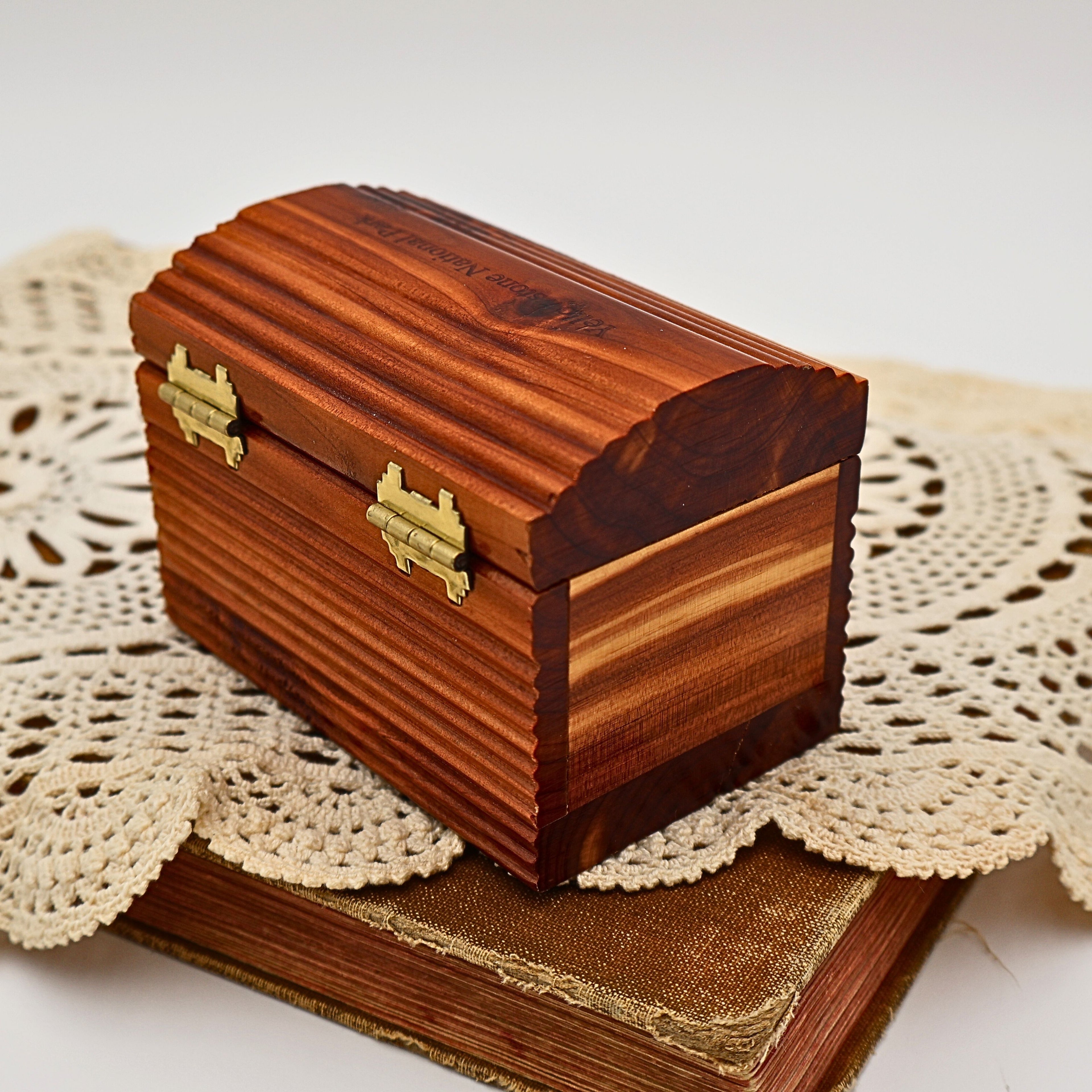 Rear three-quarter view of the Yellowstone National Park cedar keepsake box featuring decorative brass-tone hinges, ribbed sides, and contrasting natural cedar grain. The handcrafted wooden chest complements cabin decor, lodge interiors, and vintage travel collections.
