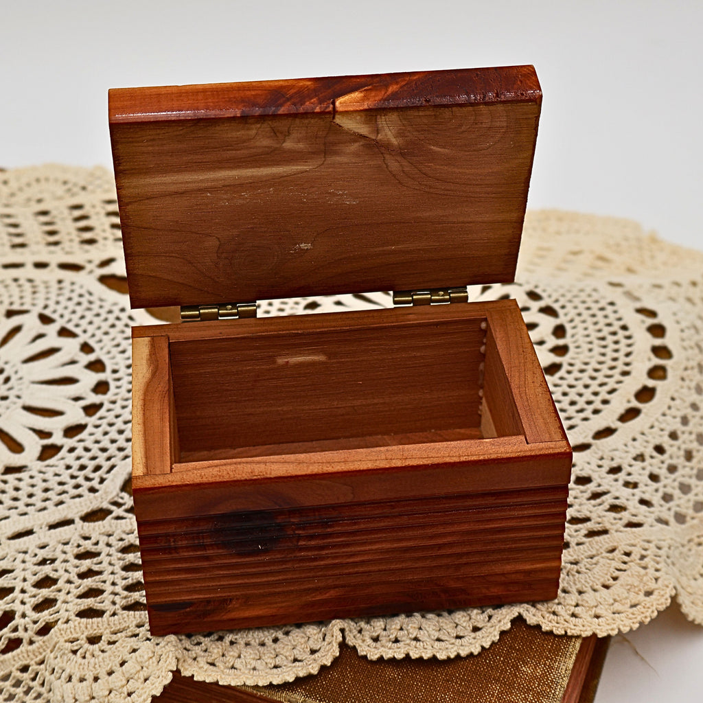 Angled view of the open Yellowstone National Park cedar keepsake box highlighting the deep storage compartment, ribbed exterior detailing, and handcrafted cedar construction. The warm wood tones make it ideal for rustic cabin decor or vintage souvenir collections.