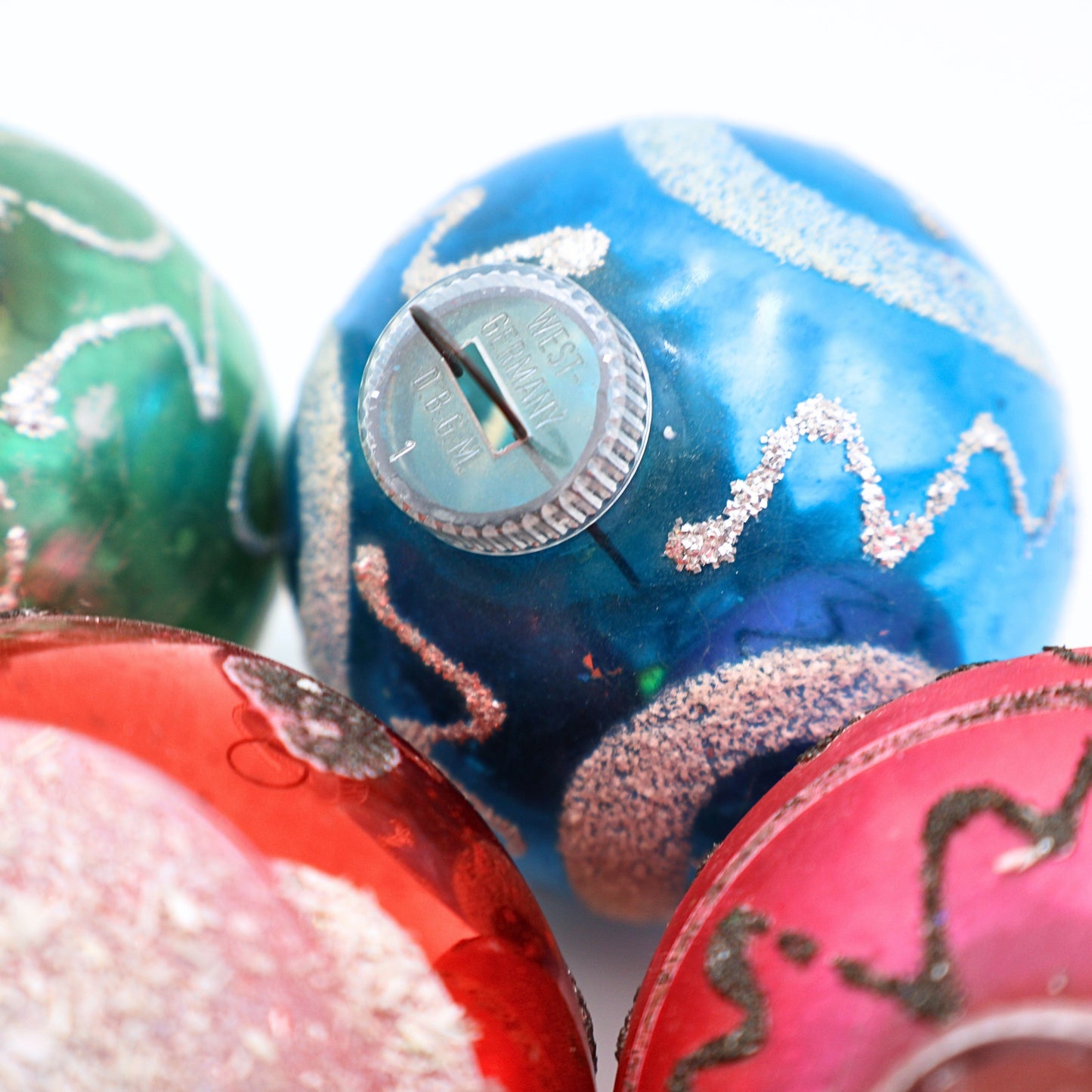 Macro detail of authentic West Germany D.B.G.M. ornament caps on vintage mercury glass Christmas ornaments