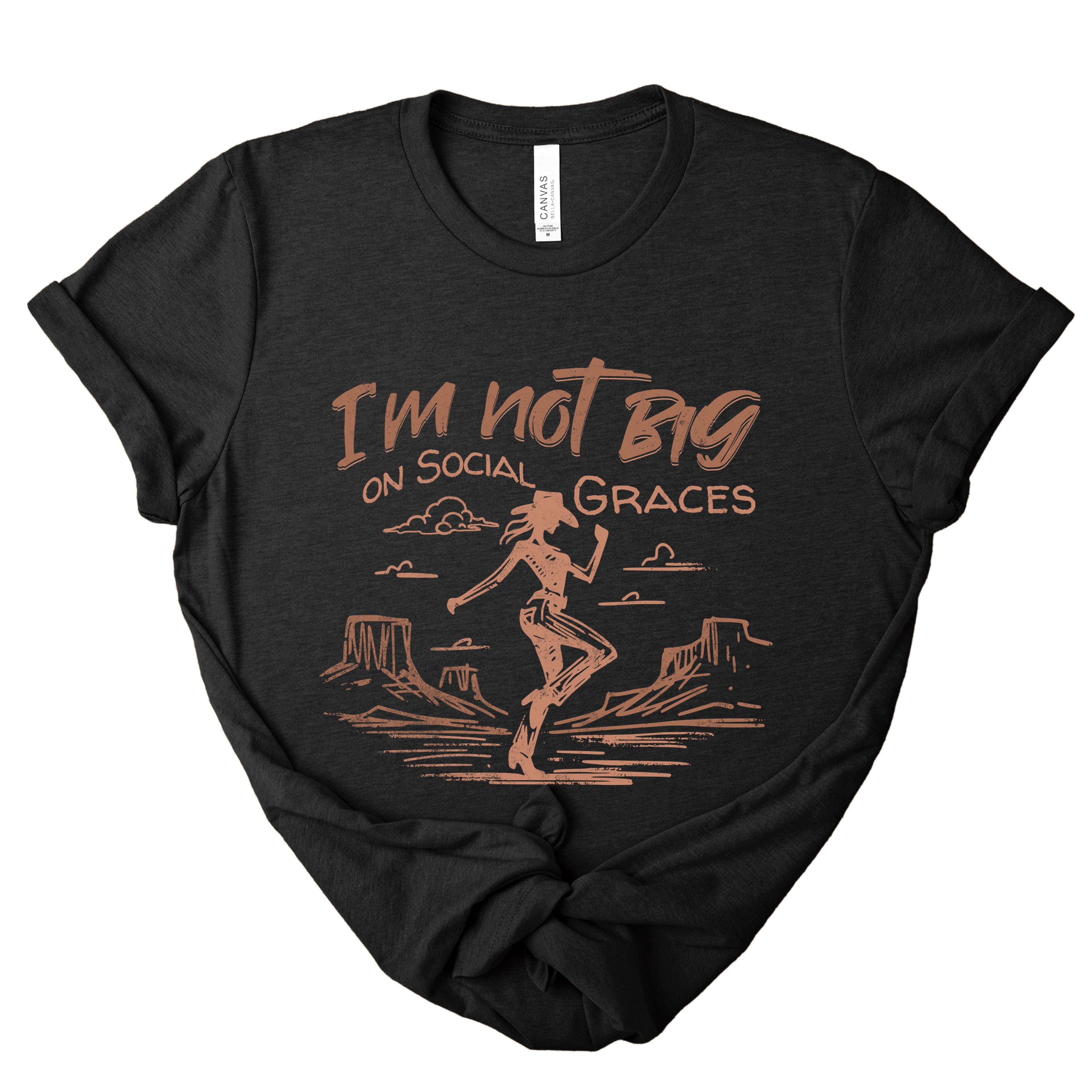 Black heather western graphic tee with copper cowgirl illustration and “I’m not big on social graces” text, edgy boutique t-shirt with vintage western style
