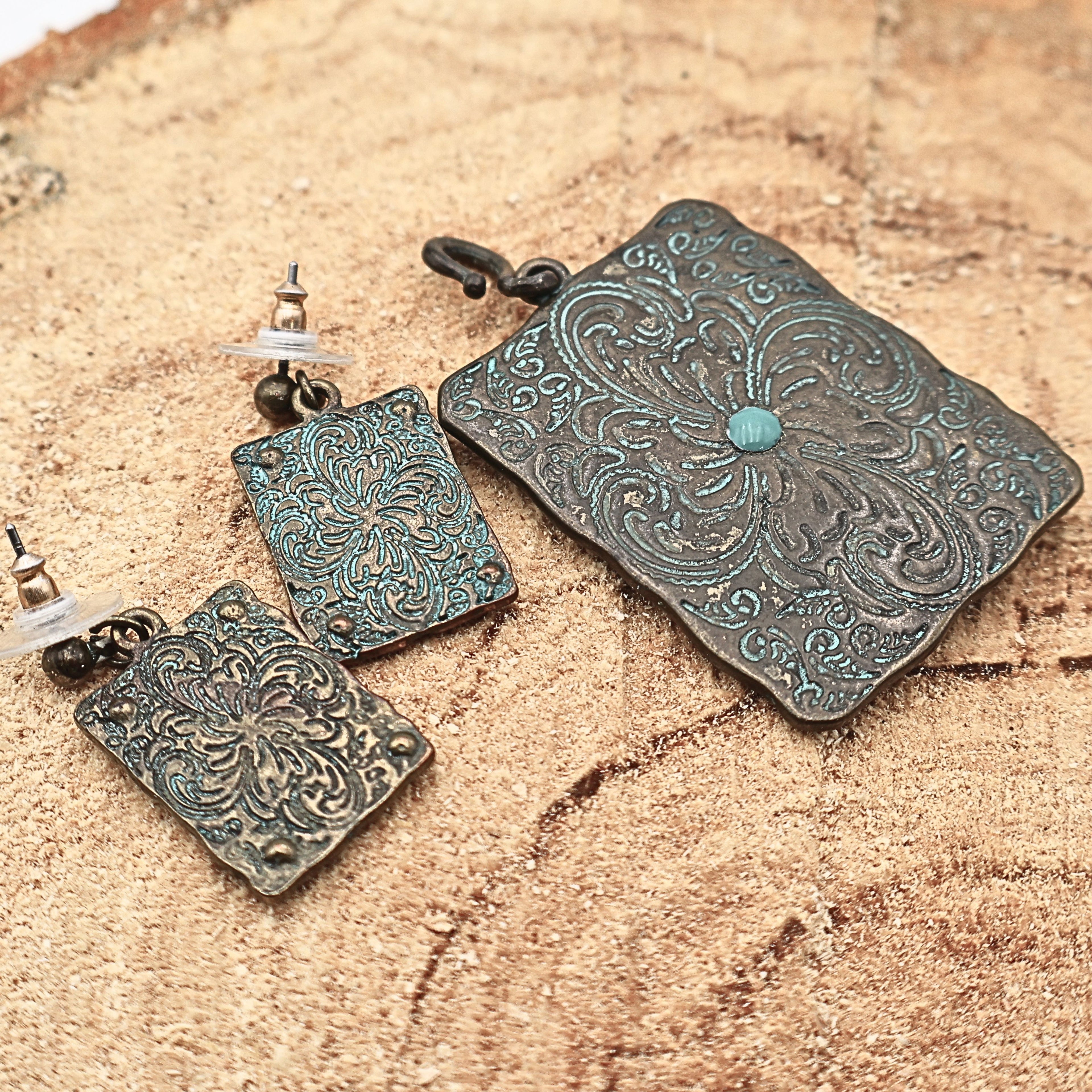 Backside view of Western longhorn jewelry set showing textured metal finish and construction details, turquoise patina earrings and pendant with engraved patterns and rustic finish, cowgirl jewelry set highlighting craftsmanship and durability, ideal for buyers wanting full detail of Western style accessories and Southwestern fashion pieces
