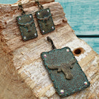 Western longhorn jewelry set featuring turquoise patina pendant and matching dangle earrings displayed on rustic wood with turquoise painted background, ornate concho detailing with rhinestone accents adds Southwestern cowgirl charm, Western style accessory perfect for rodeo outfits, country concerts, boho fashion, and rustic Western home and fashion styling