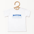 White butter foodie kids shirt displayed on hanger with retro bakery inspired graphic design. Boutique toddler birthday apparel styled for preschool outfits, baking themes, family photos, and playful celebrations.