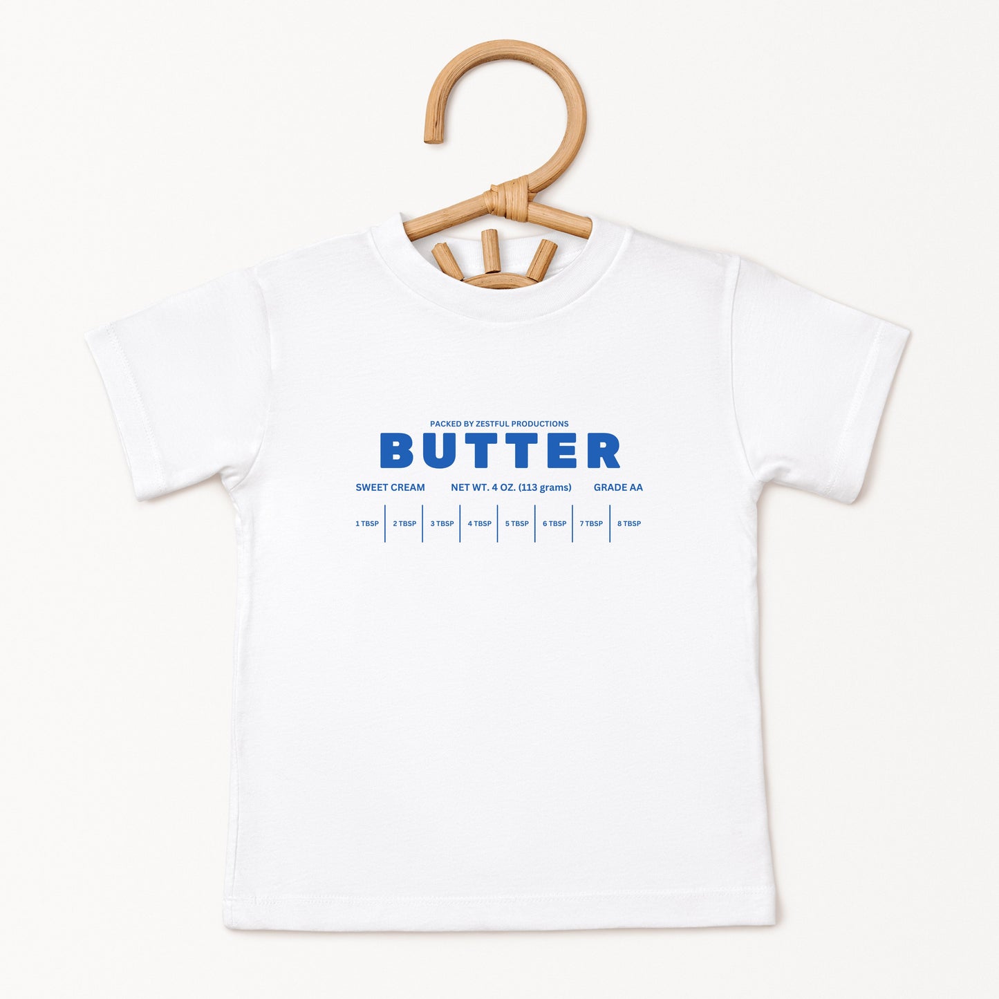 White butter foodie kids shirt displayed on hanger with retro bakery inspired graphic design. Boutique toddler birthday apparel styled for preschool outfits, baking themes, family photos, and playful celebrations.