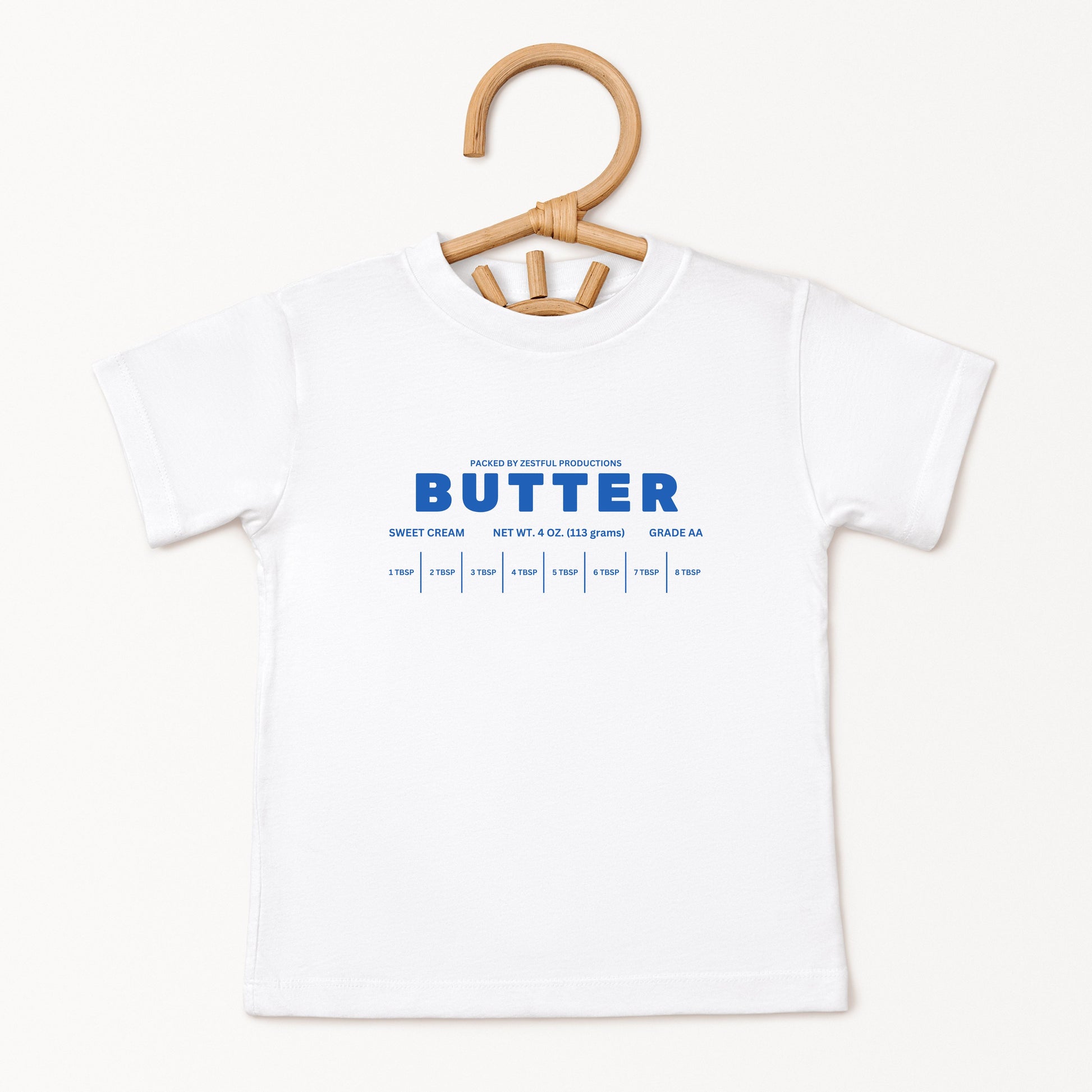 White butter foodie kids shirt displayed on hanger with retro bakery inspired graphic design. Boutique toddler birthday apparel styled for preschool outfits, baking themes, family photos, and playful celebrations.