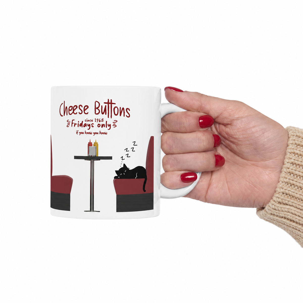 A hand with red nail polish holds a white ceramic mug featuring a White House Cafeteria restaurant illustration. The graphic shows a black cat sleeping on a red booth next to a table with two condiment bottles, with the text 'Cheese Buttons' and 'since 1968, Fridays only if you know you know' on a plain white background.
