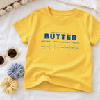 Yellow butter toddler tee flat lay with retro sweet cream baking design and foodie inspired packaging graphic. Boutique birthday shirt styled for preschool outfits, playful baking themes, and aesthetic kids apparel.