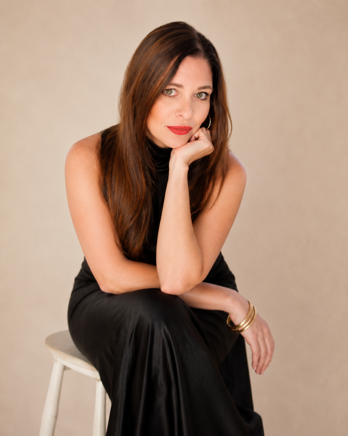 Editorial studio portrait of Zestful Productions founder Sonja Yantzer in a black dress against a soft warm ivory backdrop
