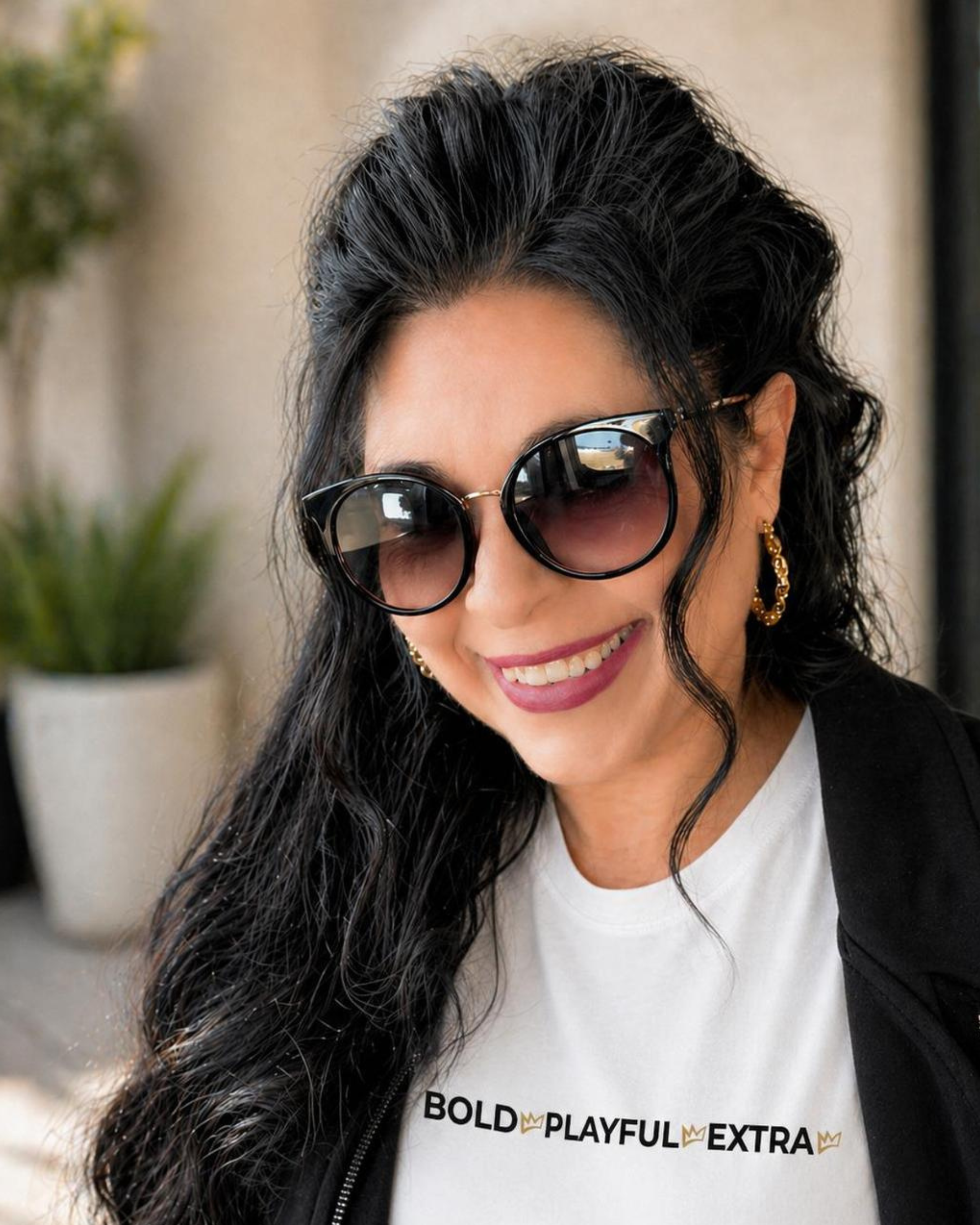 Founder of Zestful Productions Sonja Yantzer smiling in an outdoor lifestyle portrait wearing bold playful extra shirt and black jacket